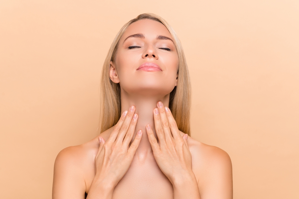 Woman touching her smooth neck after a neck lift in Austin, TX