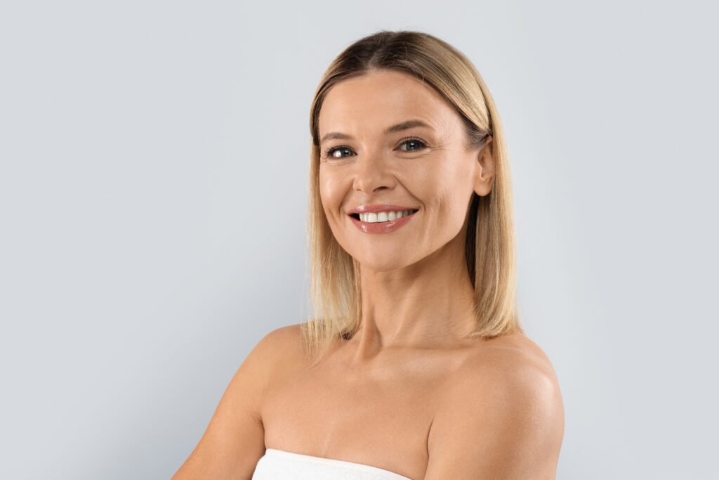 A woman smiling and showing the results of Sculptra® treatments in Austin, TX