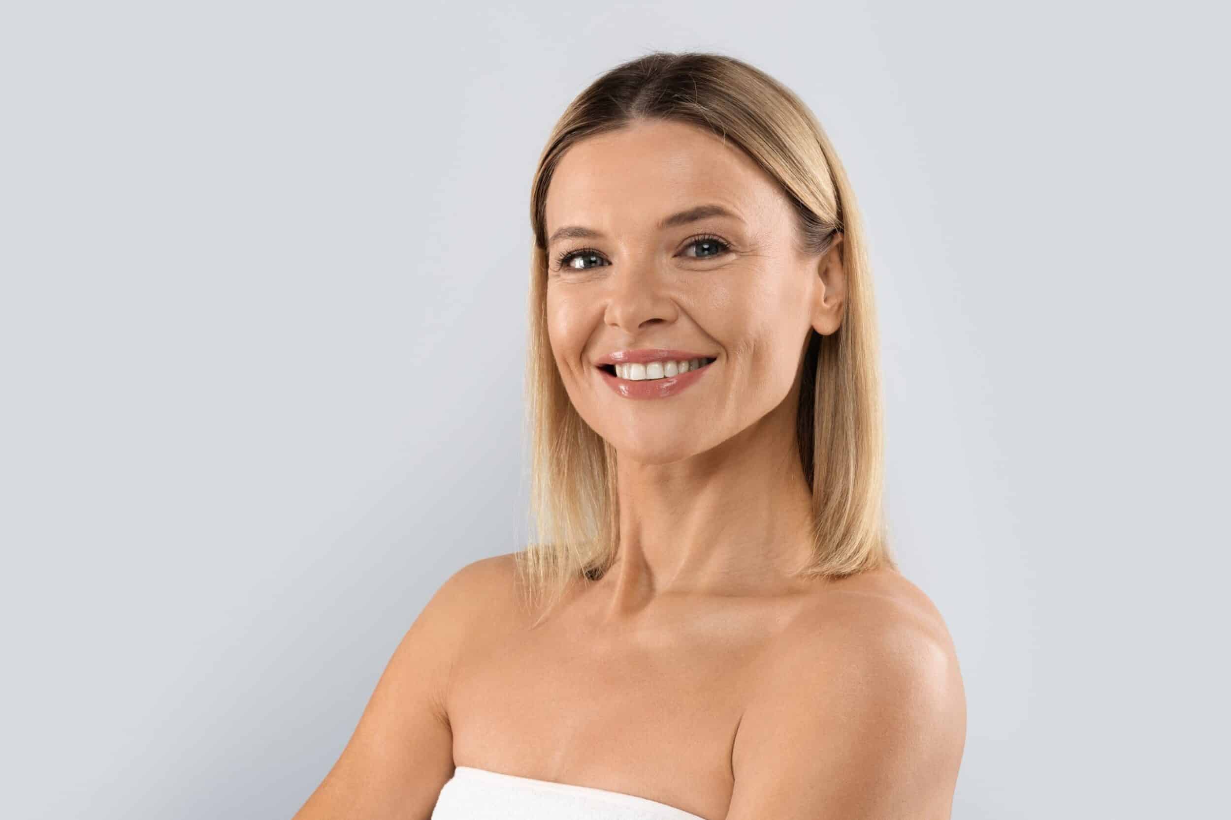A woman smiling and showing the results of Sculptra® treatments in Austin, TX