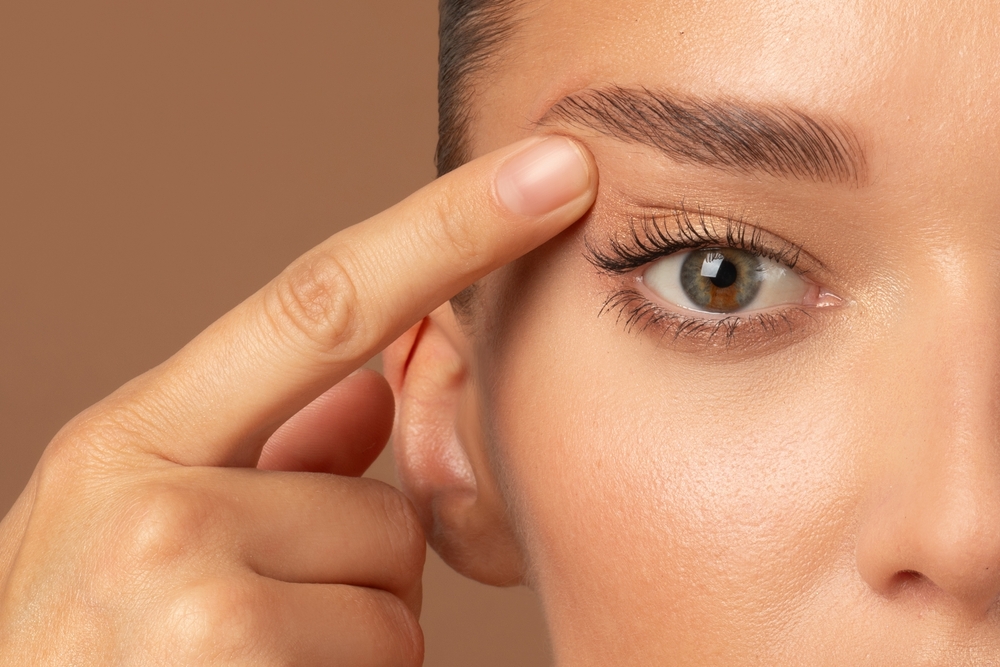 Close up of woman's eyes as she touches eyelids wanting eyelid surgery in Austin, TX