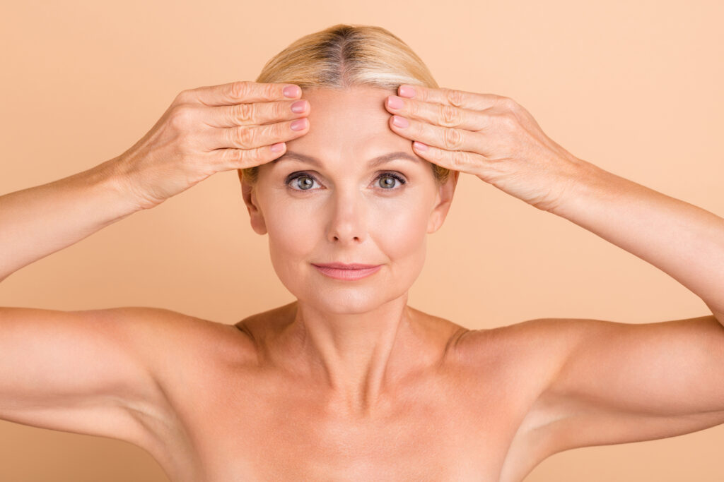 Woman with hands on her forehead showing smoothness from brow lift in Austin, TX